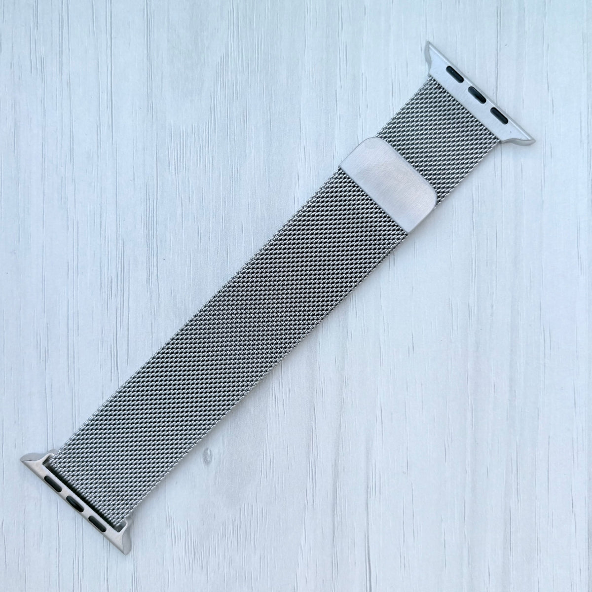 Milanese Loop Strap For Apple watch on a White wooden surface