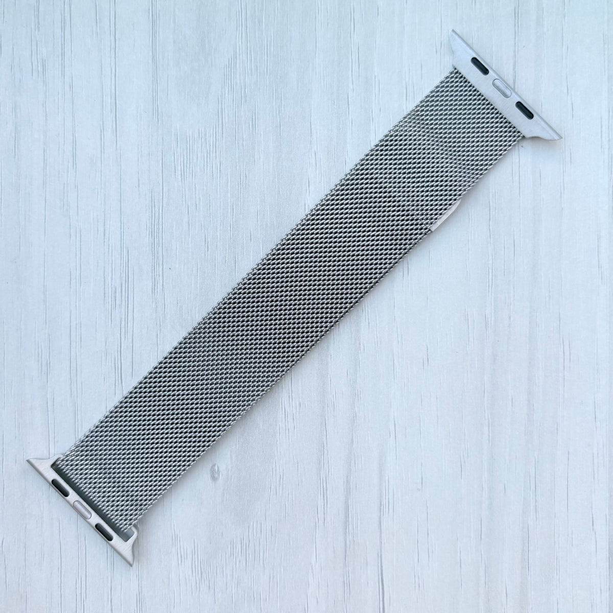 Milanese Loop Strap For Apple watch on a White wooden surface