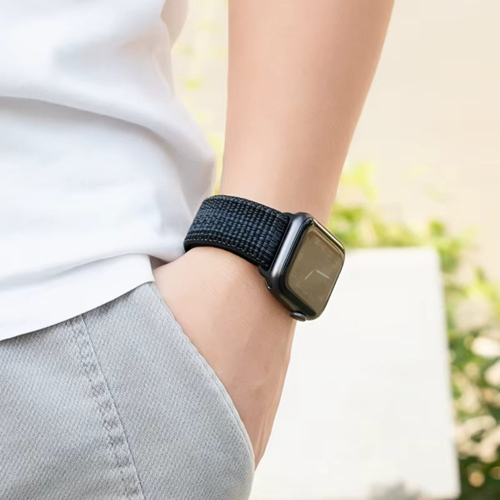 Apple Watch with Black/blue nylon band in hand – flexible, breathable, and rugged for all-day comfort.