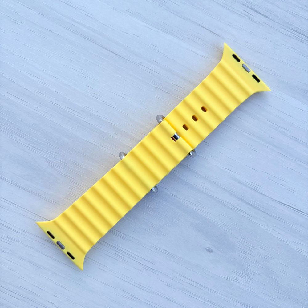 Ocean Band for Apple Watch in Yellow with Silver Buckle, Back View on Light Wooden Surface