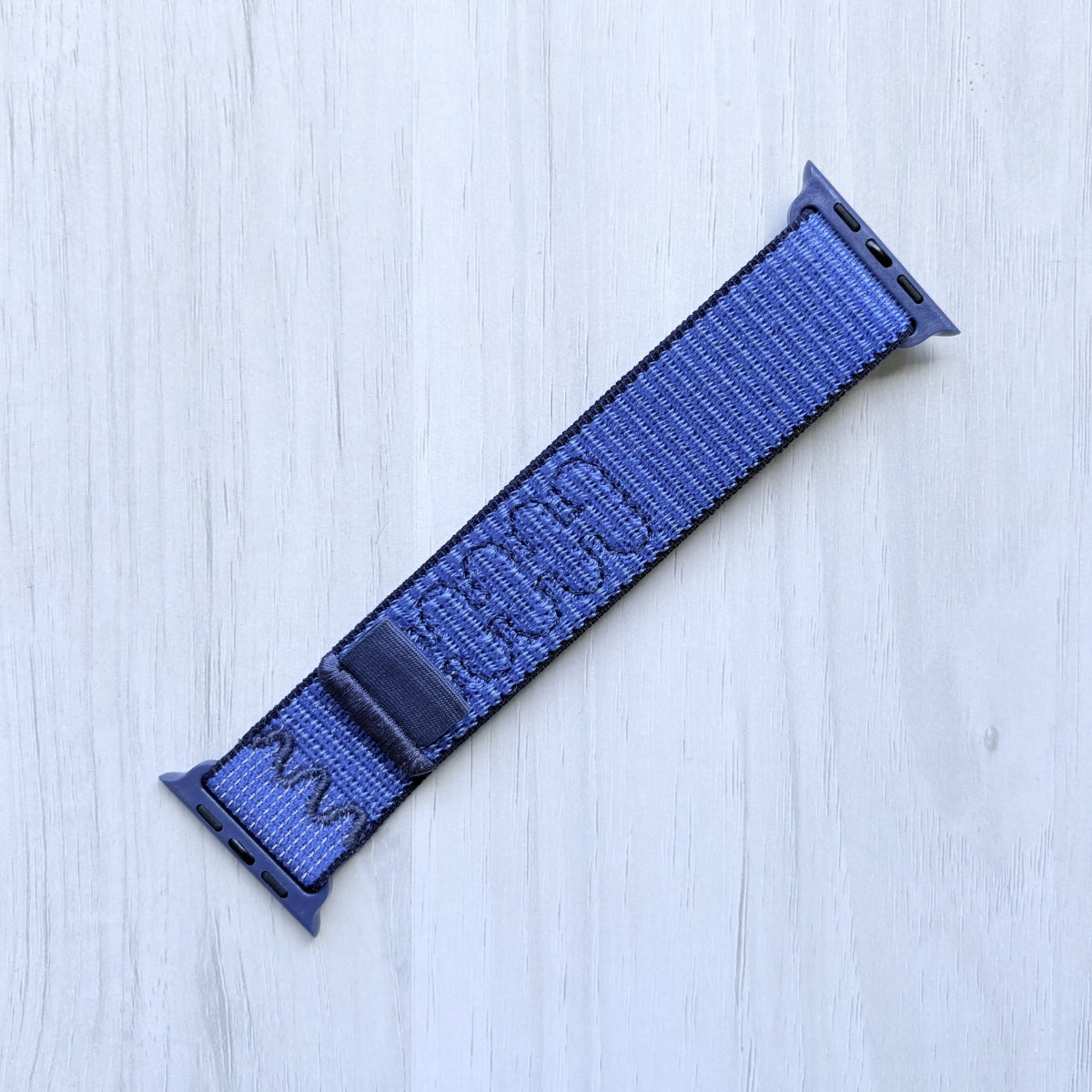 Blue Ribbon Nike sport loop band for apple watch on a white background, front side.