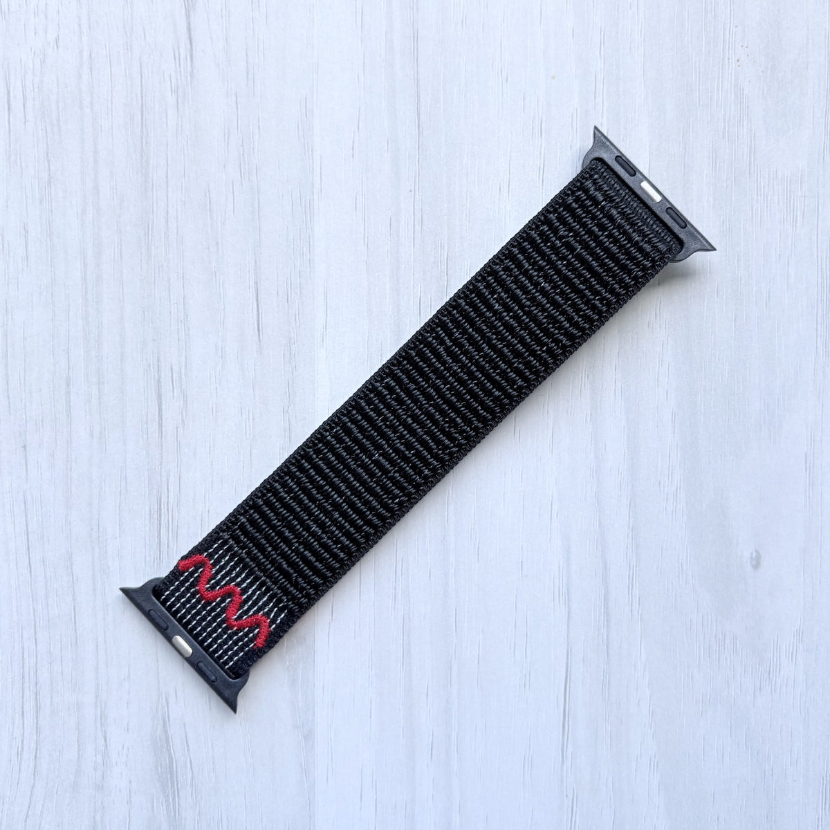 Midnight Black Nike sport loop band for apple watch on a white background, front side.