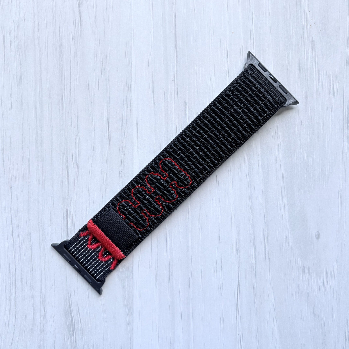 Midnight Black Nike sport loop band for apple watch on a white background, front side.