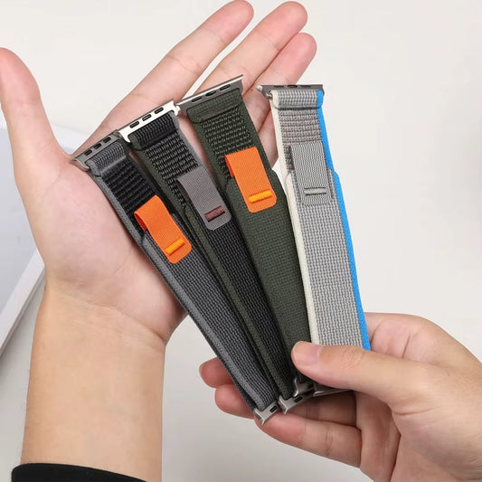 Multiple Trail Loop Apple Watch bands in a variety of colors including Yellow Beige, Blue Gray, Black Gray, Orange Beige, Gray White, Blue Black, Army Green, Orange, and Sea Salt—shown together to highlight the breathable nylon design and sporty, stretchable fit for Apple Watch Ultra and Series 9/8/7.