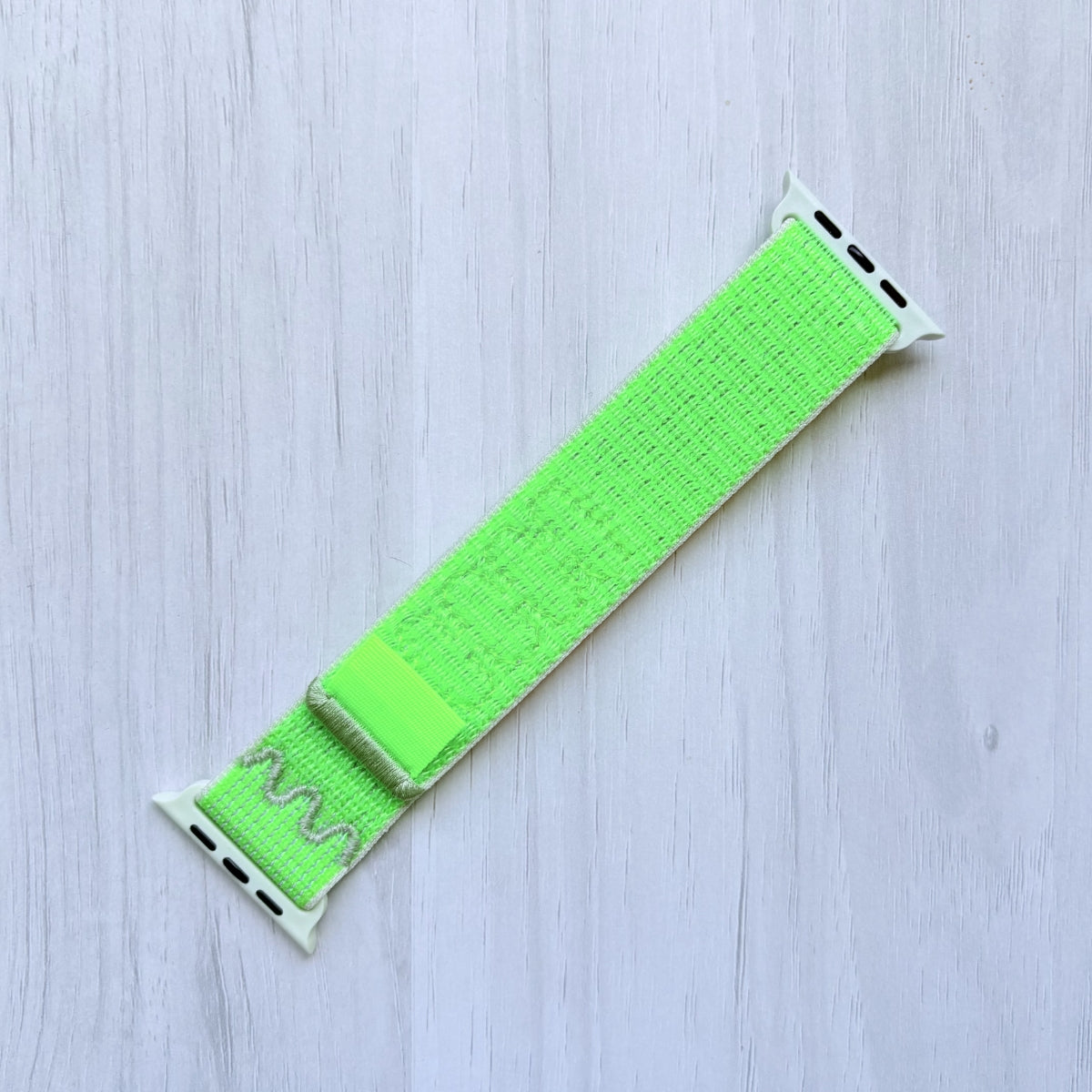 Volt Splash Apple watch strap on a light wooden surface, Front side
