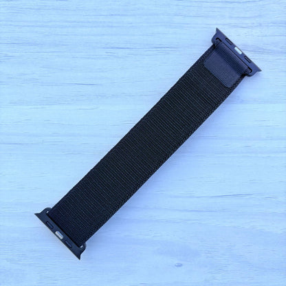 Black Alpine loop Band for apple watch with Black finish on a white wooden background back view