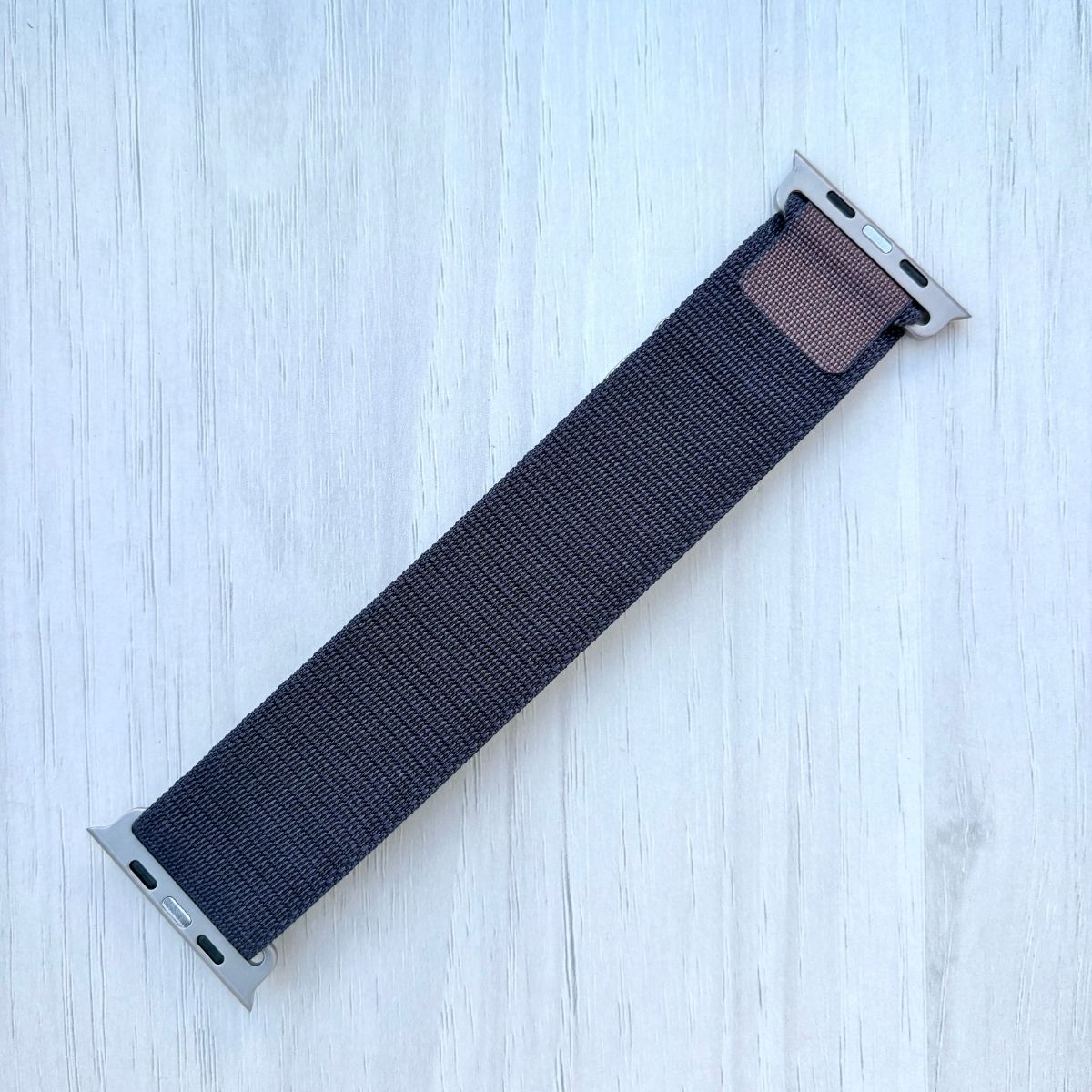 indigo woven alpine loop apple watch strap on a light wooden surface