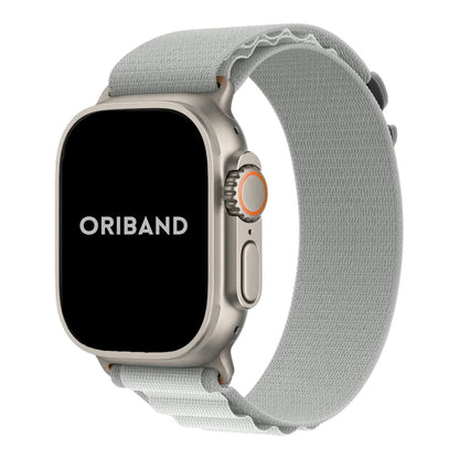Apple Watch Ultra with a sleek titanium case paired with a light gray Alpine Loop band, showcasing a rugged, durable design perfect for outdoor and everyday wear