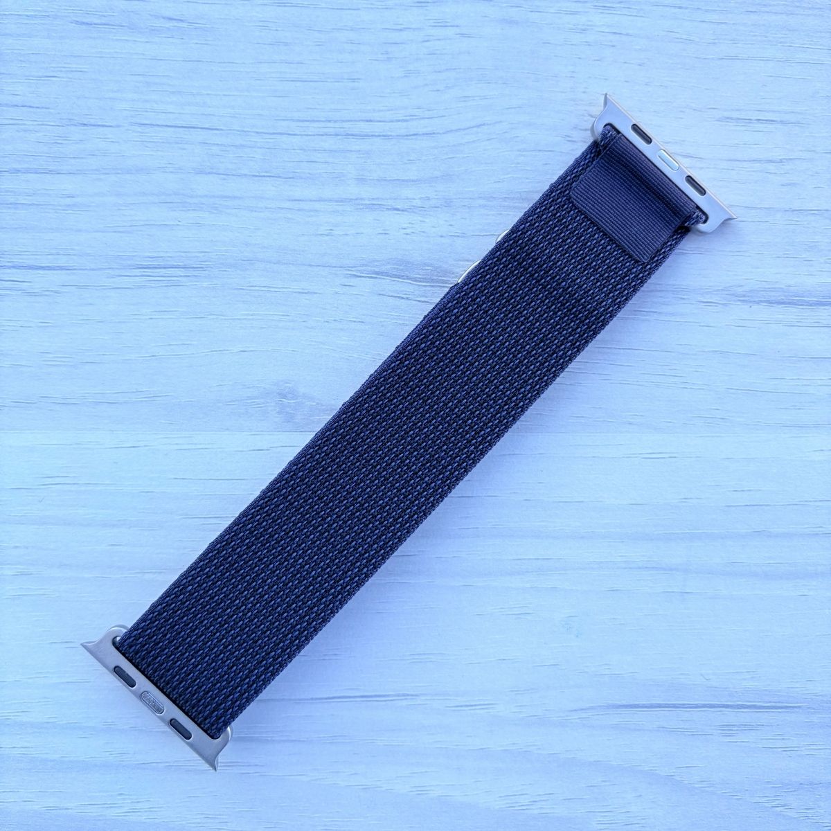 Midnight Blue Alpine Loop nylon band with titanium finish back view in a light white wooden background