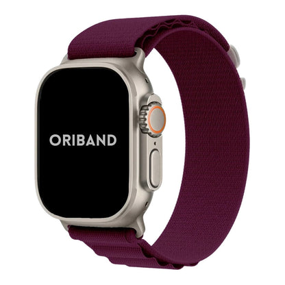 Apple Watch Ultra with a sleek titanium case paired with a wine red Alpine Loop band in a white background, showcasing a durable design perfect for outdoor and everyday wear.