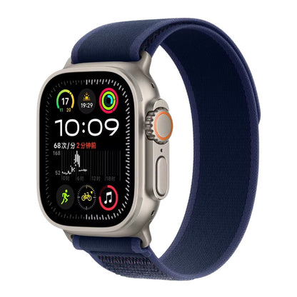 Titanium Apple Watch Ultra with a Blue Trail loop band on a white background