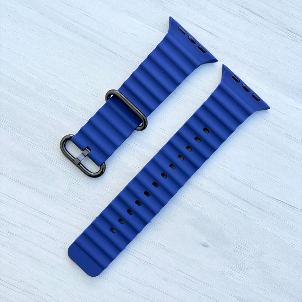 Ocean band for Apple watch in midnight blue with Black buckle on a light wooden surface