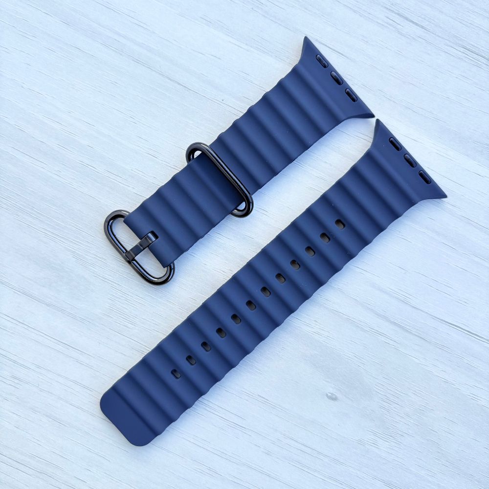 Ocean band for Apple watch in Navy Color with Black buckle on a light wooden surface