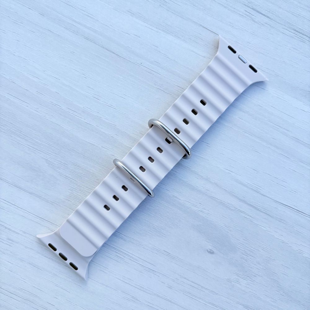 Ocean Band for Apple Watch in Starlight with Silver Buckle, Front View on Light Wooden Surface