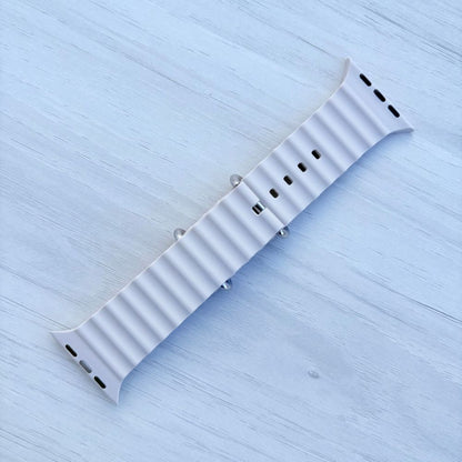 Ocean Band for Apple Watch in Starlight with Silver Buckle, Back View on Light Wooden Surface