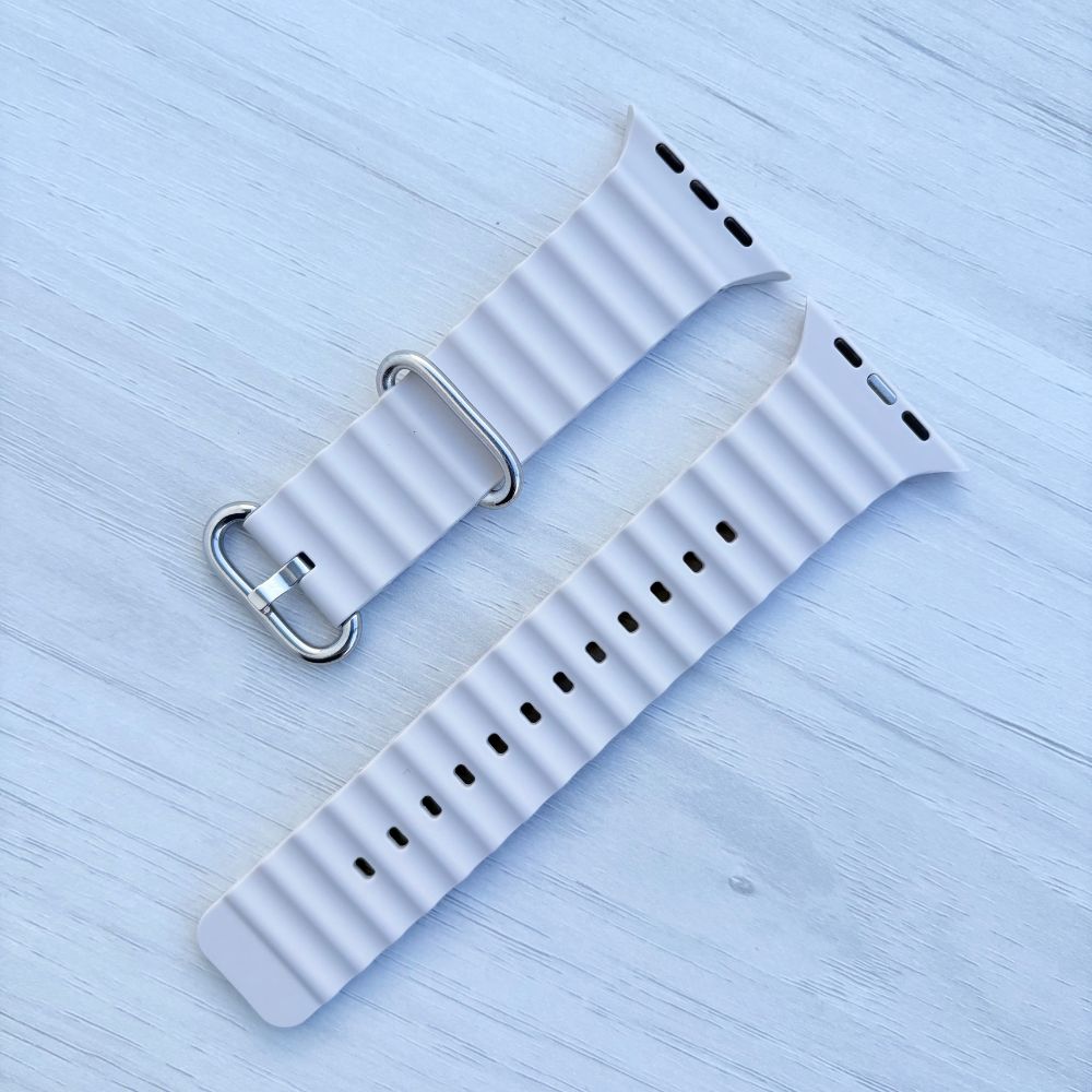 Ocean Band for Apple Watch in Starlight with Silver Buckle, on Light Wooden Surface