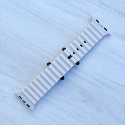 Ocean Band for Apple Watch in Starlight with Black Buckle, Back View on Light Wooden Surface