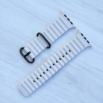 Ocean Band for Apple Watch in Starlight with Black Buckle, on Light Wooden Surface