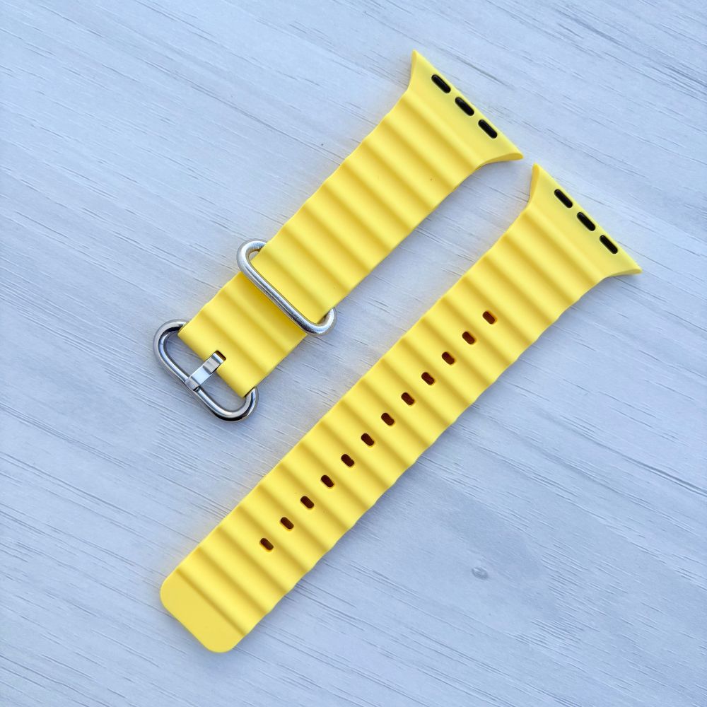 Ocean Band for Apple Watch in Yellow with Silver Buckle, on Light Wooden Surface