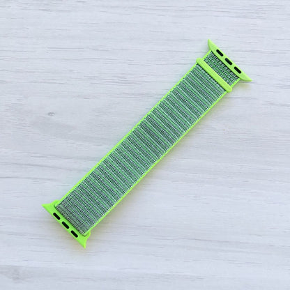 Flash Sport Loop Apple Watch Band with woven nylon design displayed on a light wooden surface, front view.