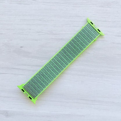 Flash Sport Loop Apple Watch Band with woven nylon design displayed on a light wooden surface, back view.